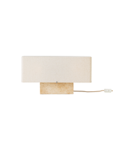 Load image into Gallery viewer, Front view of the Nonna Table Lamp with a rectangular travertine base and a wide, sand-coloured linen lampshade.
